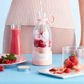 Mini Batidora Portátil FitPro rosa con frambuesas y hielo